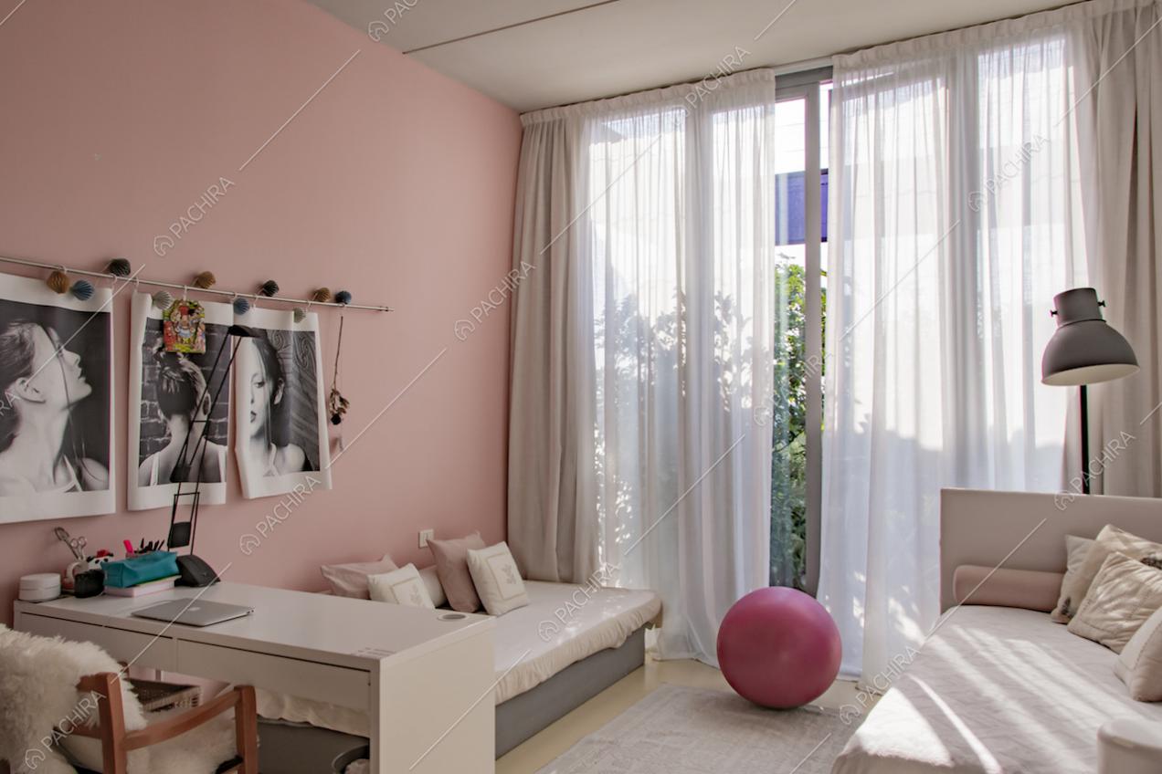 Foto in bianco e nero appese alla parete rosa e divanetto 