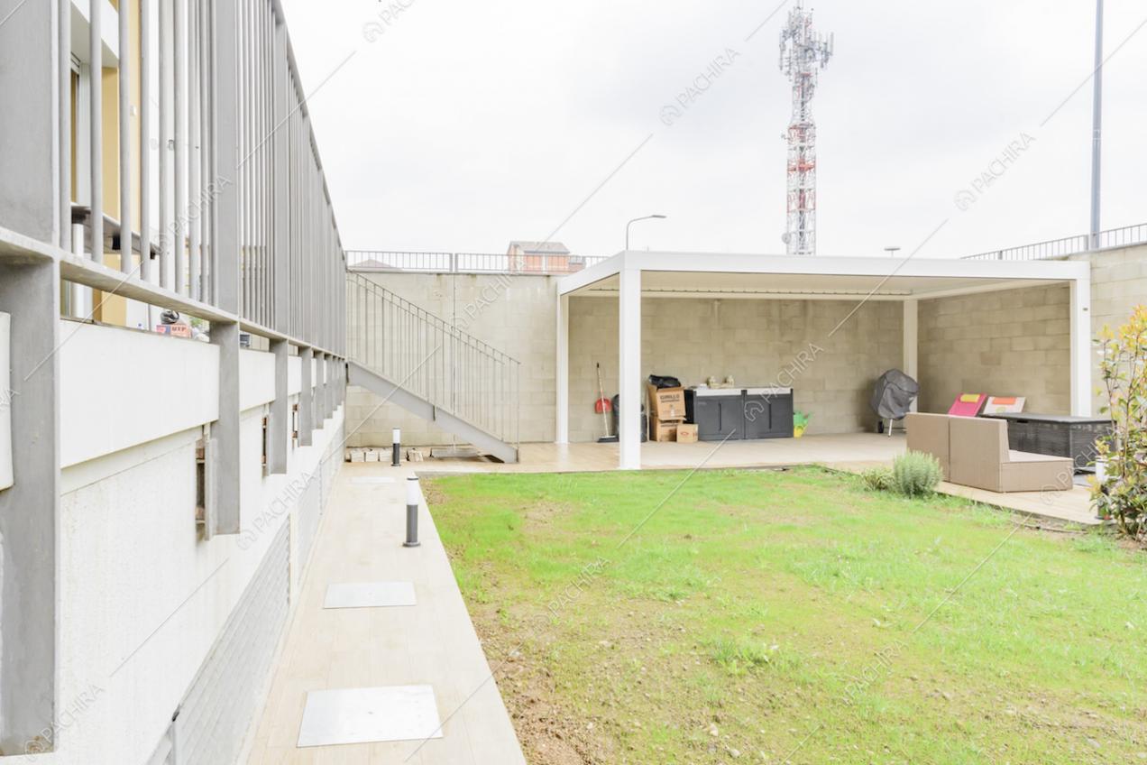 Dal giardino della location vista sulla pergola, sul salotto da esterni e sulle scale