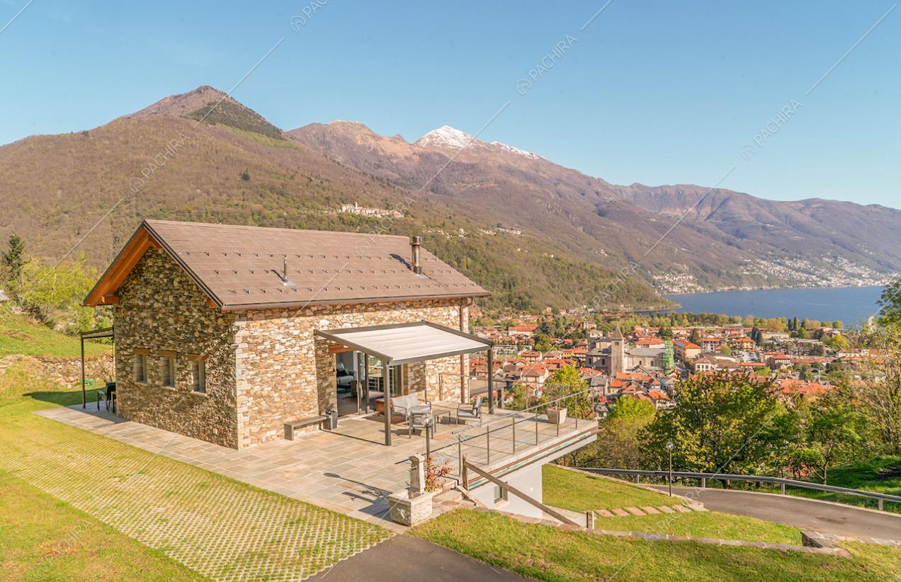 Dal giardino vista sulla location dagli esterni in pietra e veranda con salotto sulla terrazza
