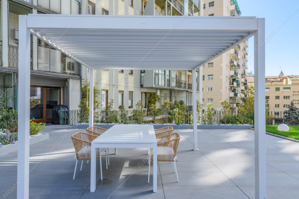 Gazebo bianco con tavolo da pranzo e sedie sulla terrazza