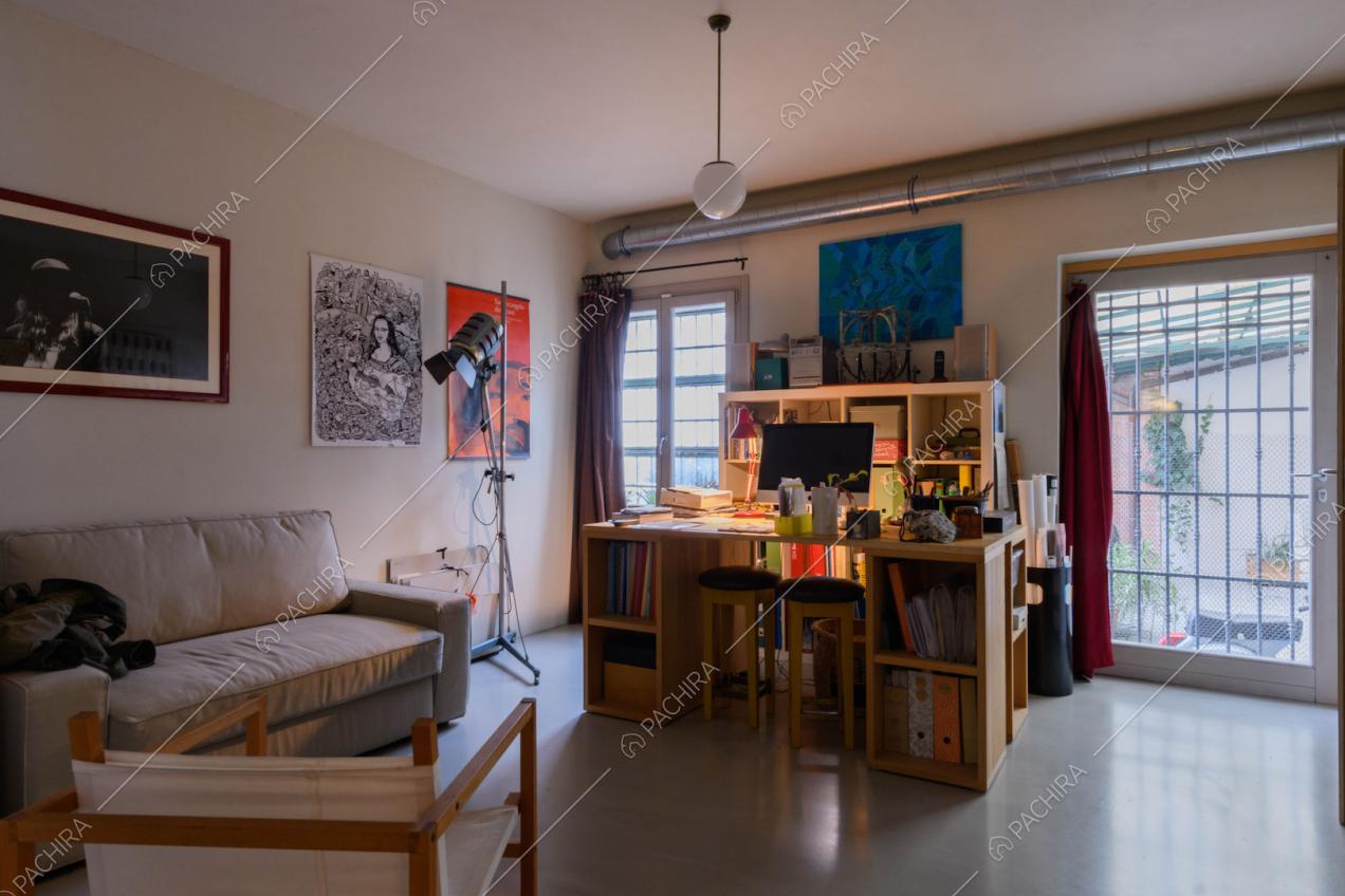 Studio con porta-finestra per accedere al giardino e pavimento in resina