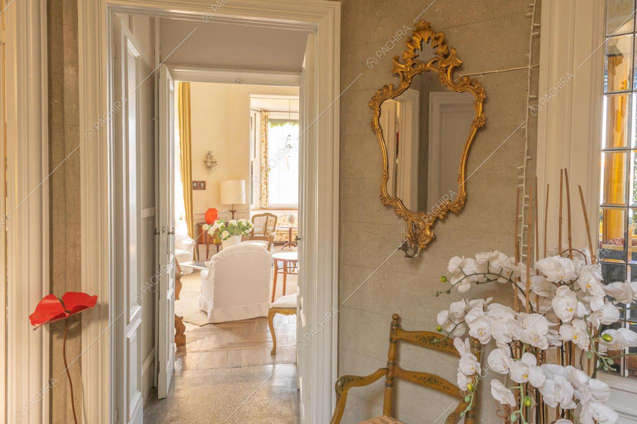 Visuale su zona living, con arredi in tonalità chiare e specchio d'epoca