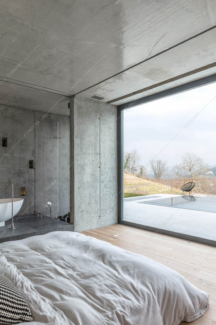 Camera da letto matrimoniale con pavimento in parquet, vasca e vista sulla piscina
