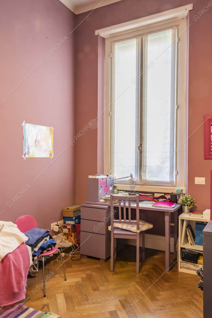 Pareti rosa nella camera da letto dei bambini dal pavimento in parquet a spina di pesce