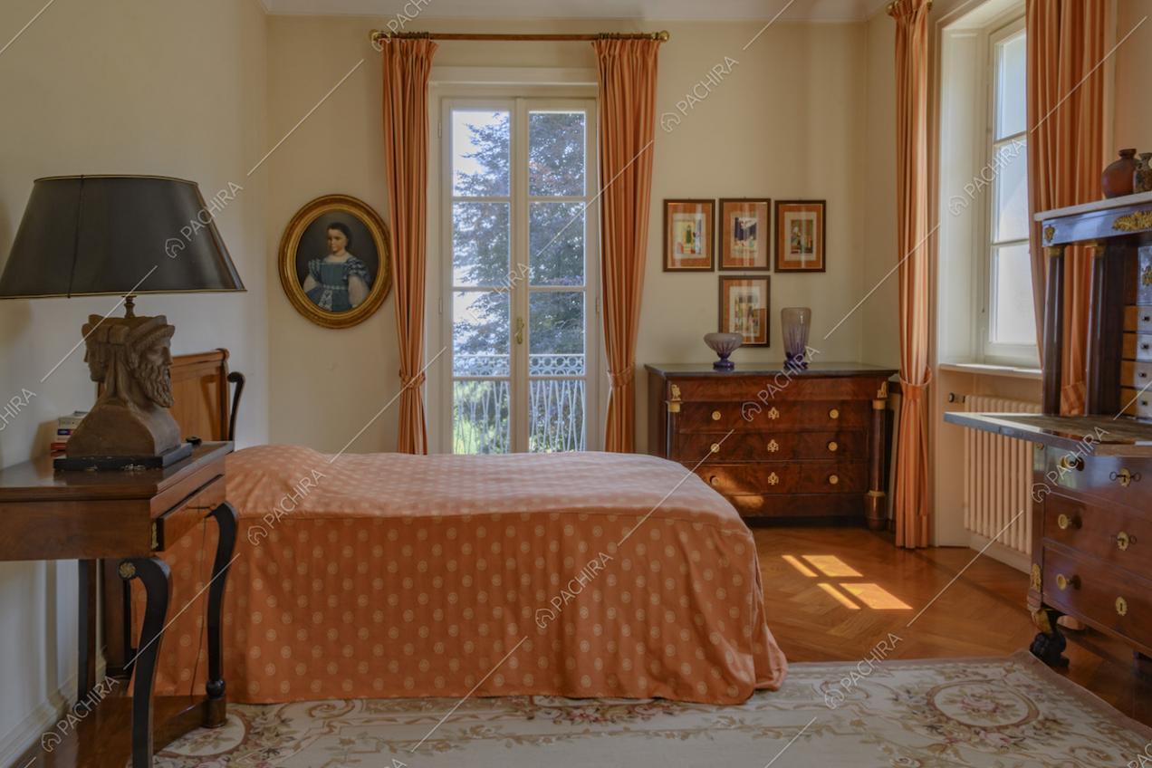 Camera da letto con mobili d'epoca e quadri appesi alle pareti
