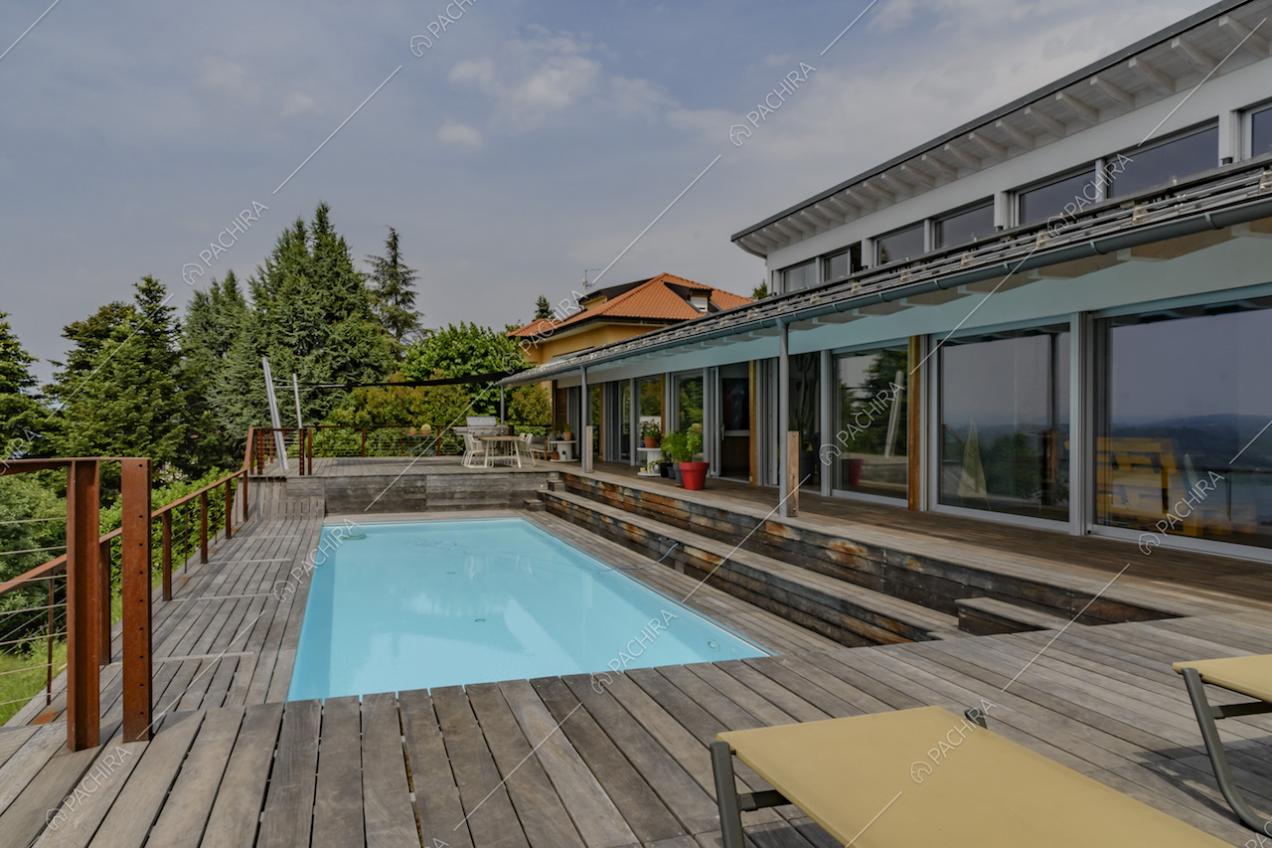 Vista panoramica dalla terrazza con piscina, lettini e pavimento in parquet da esterni