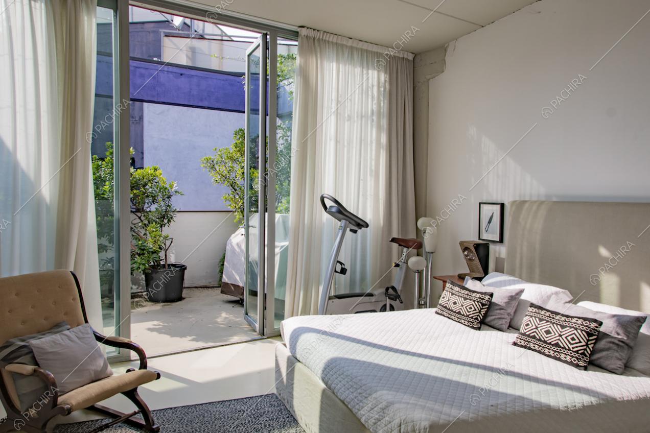 Camera matrimoniale con grande vetrata e accesso alla terrazza