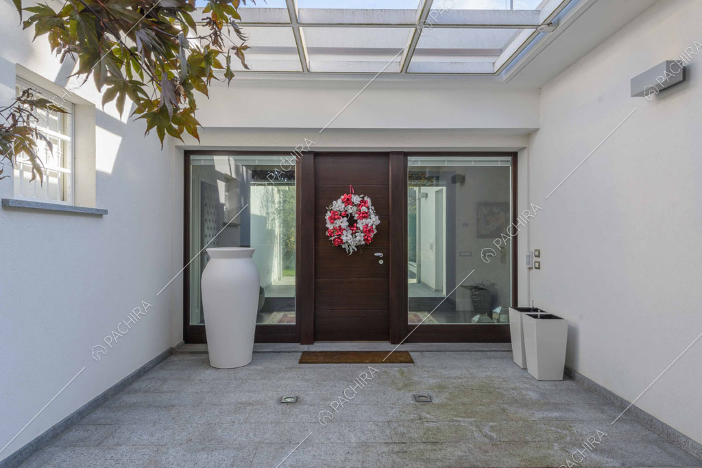 Portico moderno con lucernario, pareti bianche e grande vaso