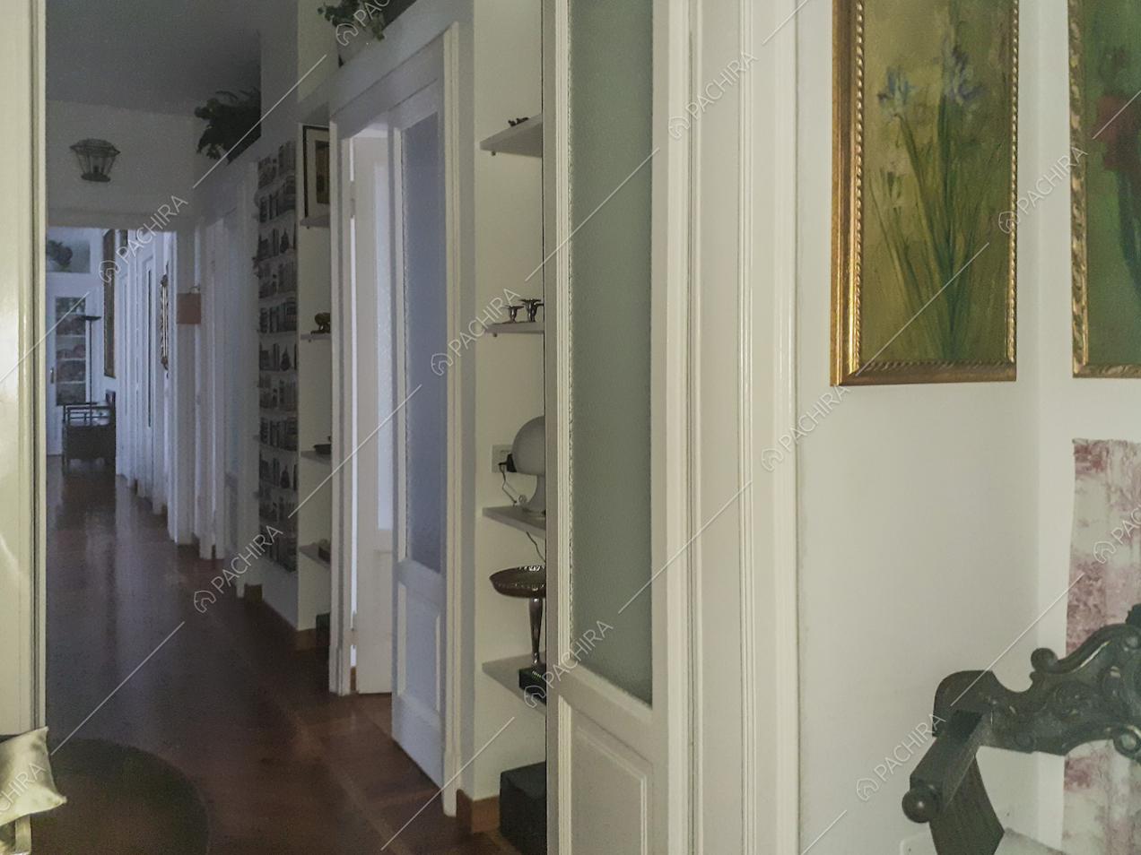 Corridoio con porte d'epoca e mensole con soprammobili