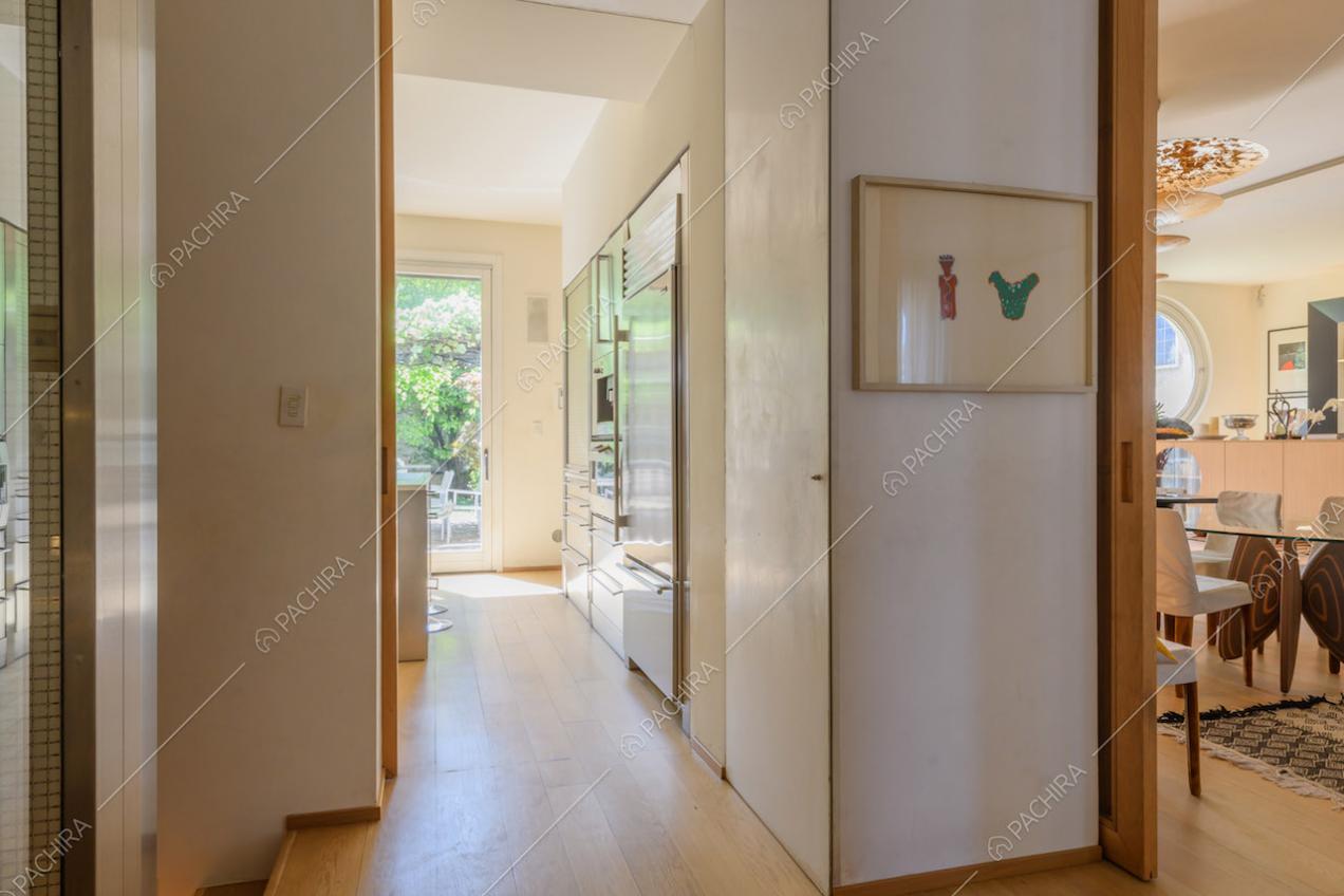Luminoso corridoio con pavimento in parquet e porta-finestra