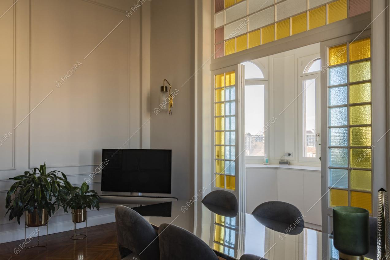 Tavolo da pranzo e vetrate colorate all'ingresso della cucina