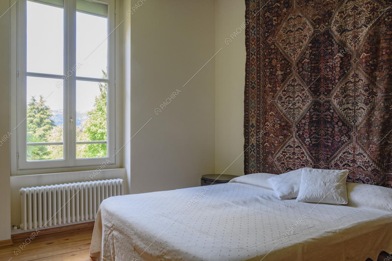 Camera matrimoniale con arazzo dietro al letto