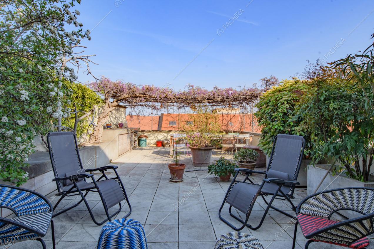 Ampia terrazza con rampicanti, sedie e vista sullo skyline