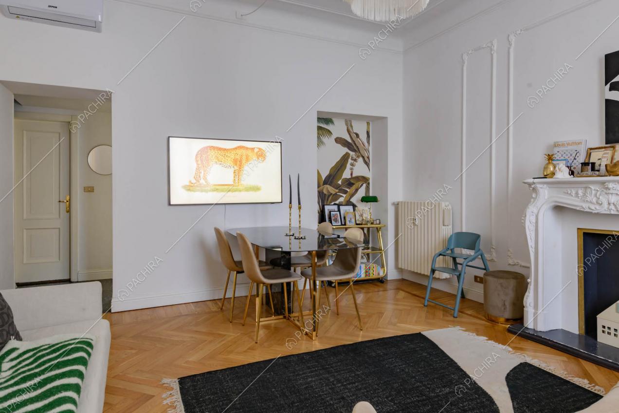 Tavolo da pranzo nel salotto con boiserie su pareti e soffitto e camino