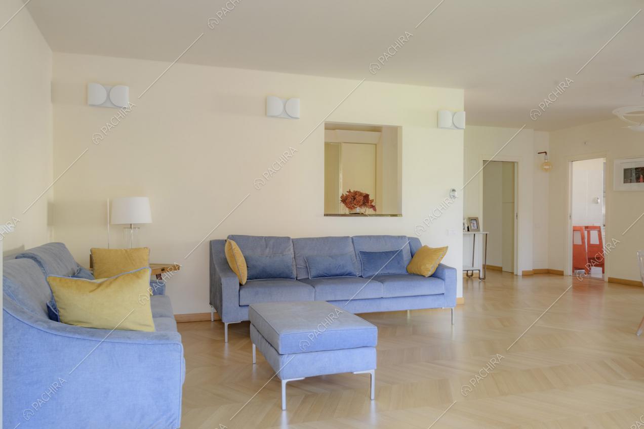 Ampio salotto con divani e pouf con gambe in acciaio
