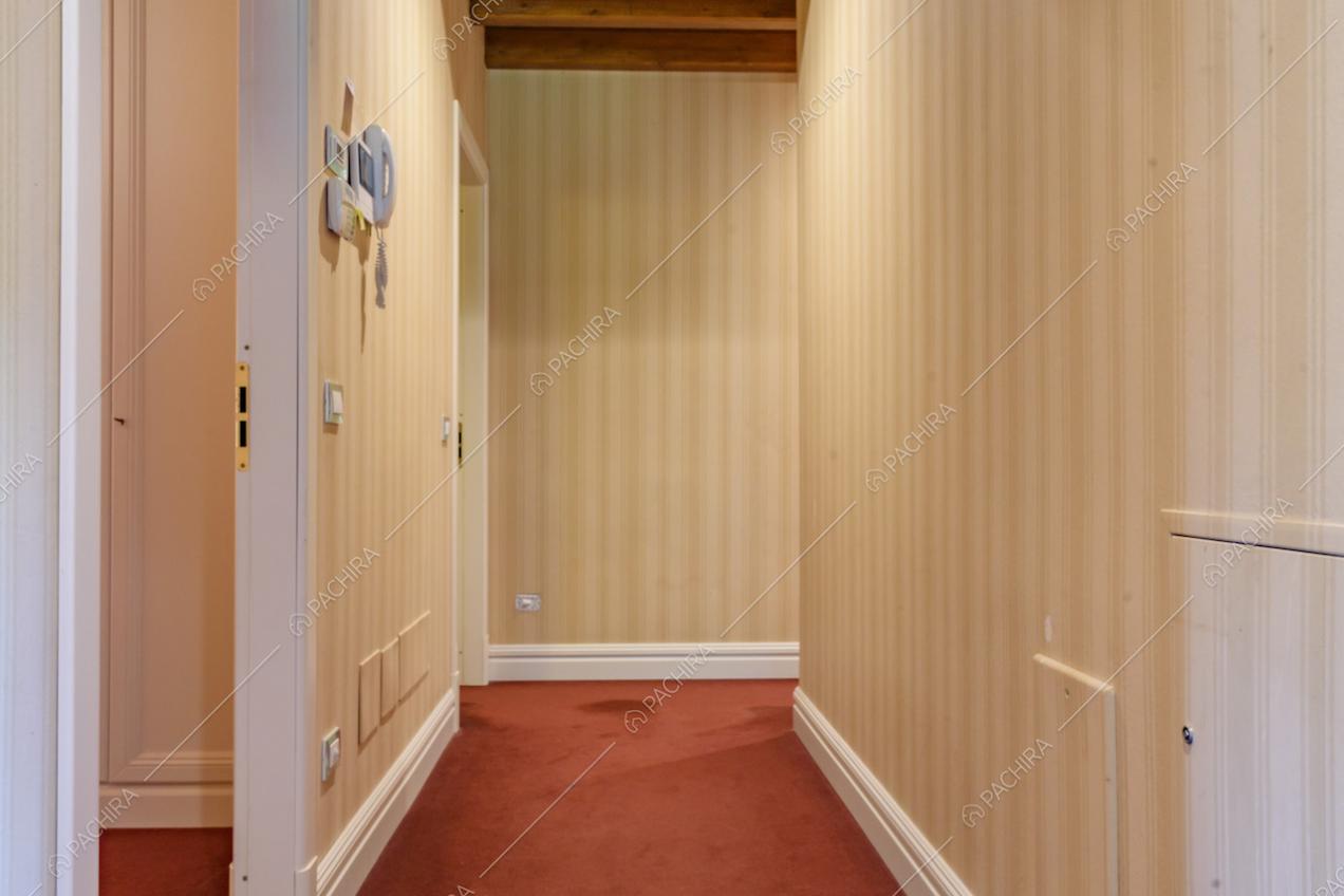 Corridoio con moquette rossa e carta da parati