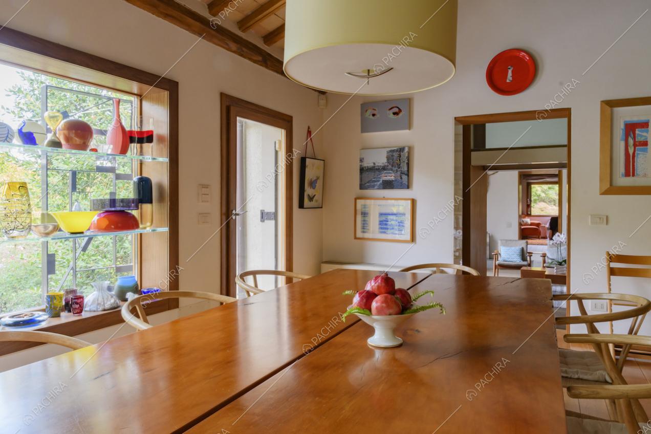 Tavolo da pranzo in legno con sedie e soprammobili colorati