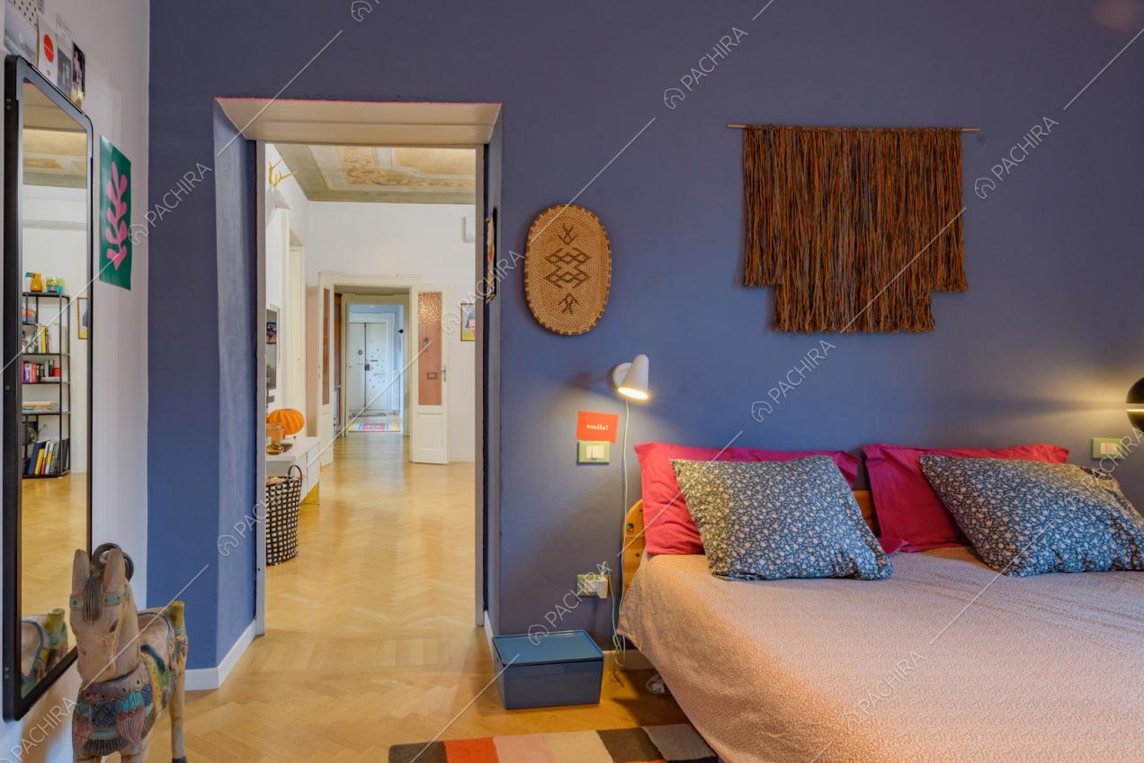Pareti blu nella camera da letto matrimoniale con pavimento in parquet a spina di pesce