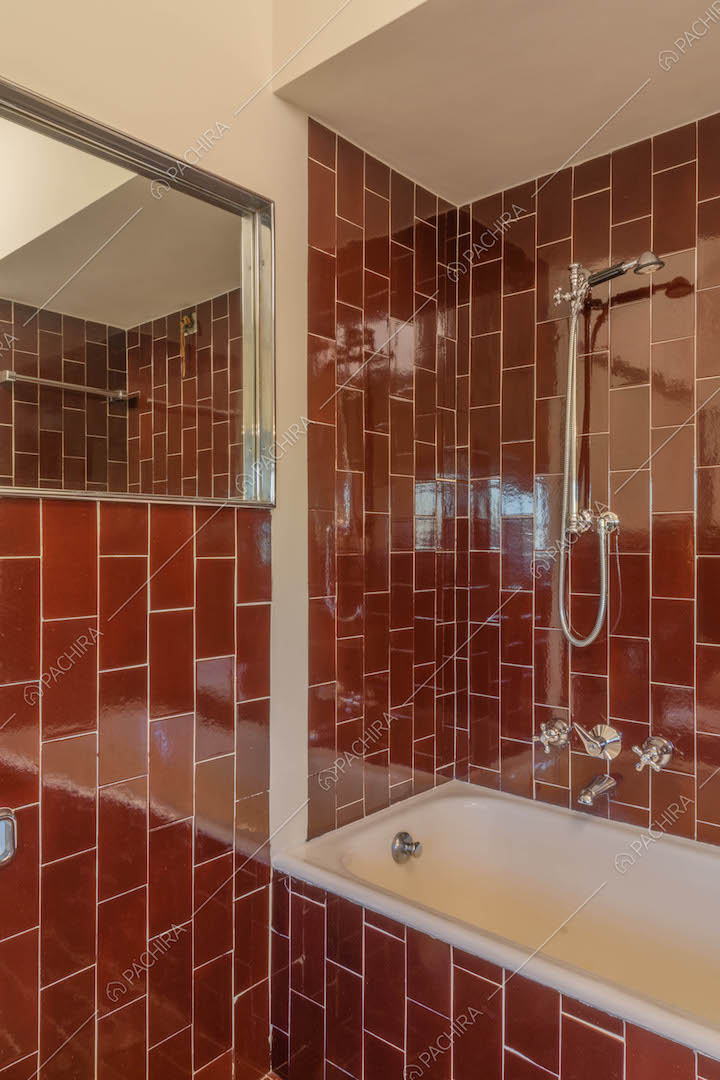Vasca nel bagno con pareti e pavimento in piastrelle rosse