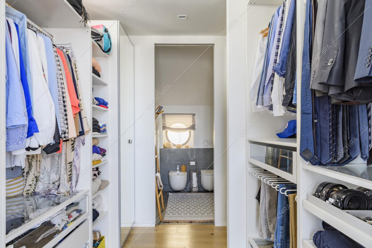 Ampia cabina armadio con pavimento in parquet porta al bagno privato