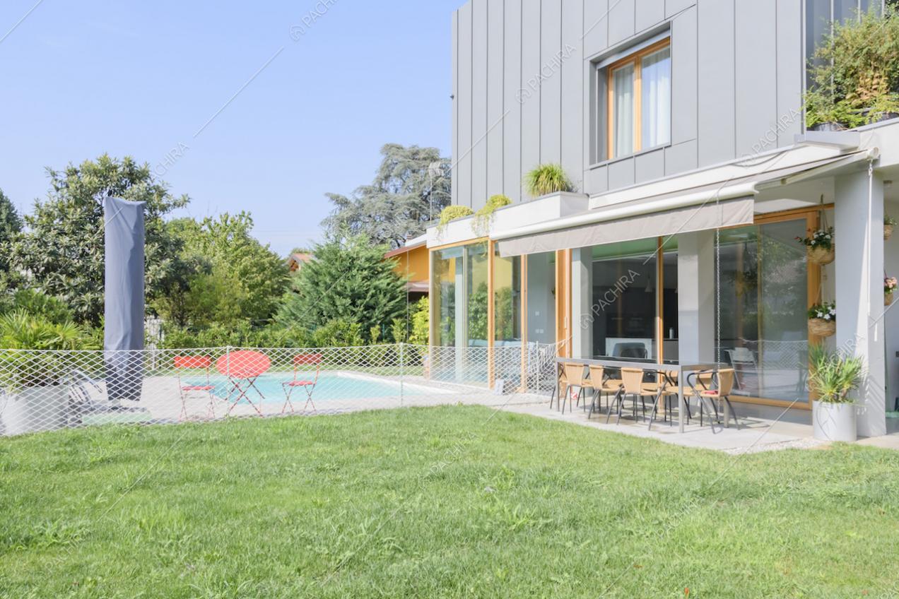 Patio con veranda, tavolo con sedie, piscina e sdraio