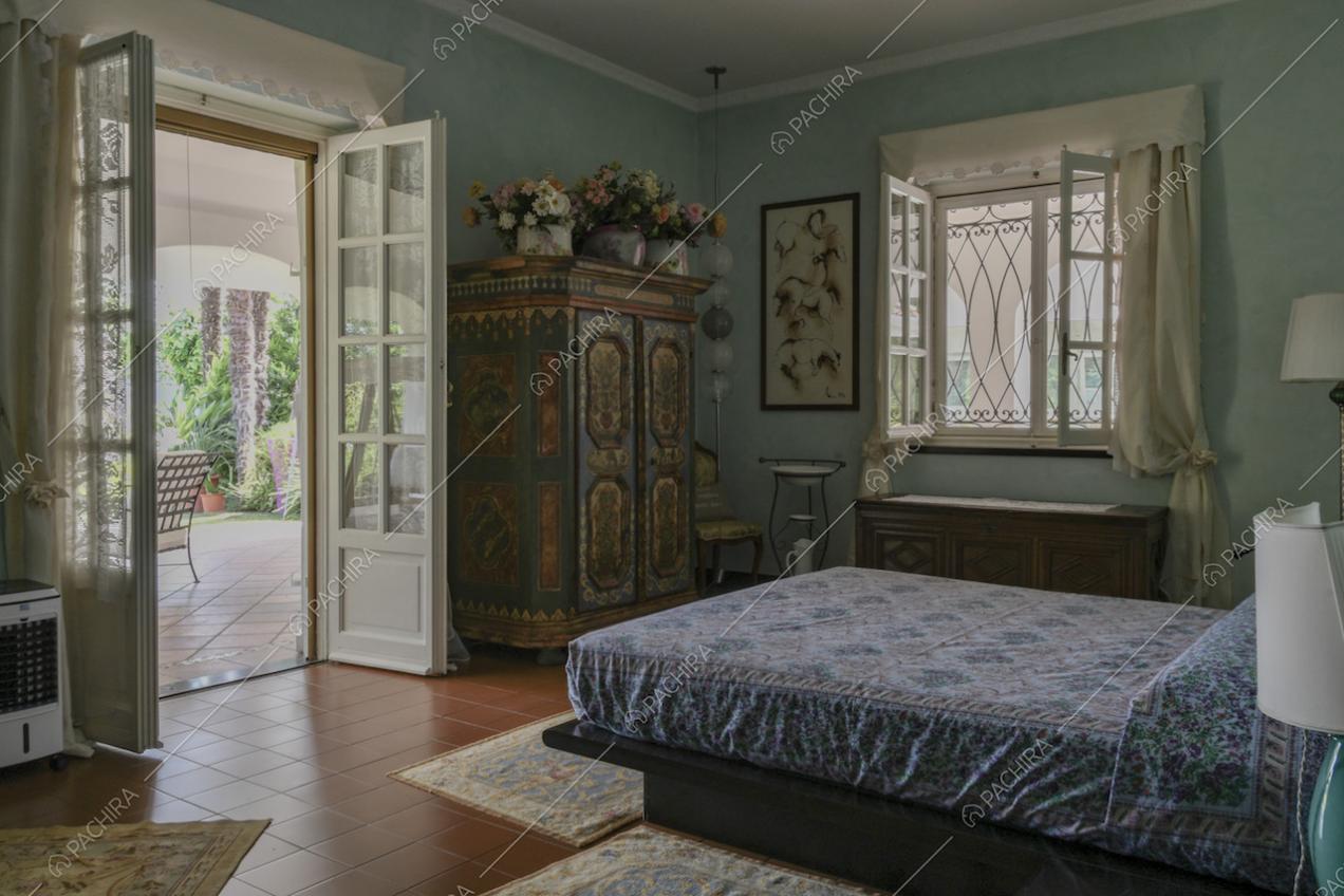 Camera da letto matrimoniale dall'arredamento classico con accesso alla veranda