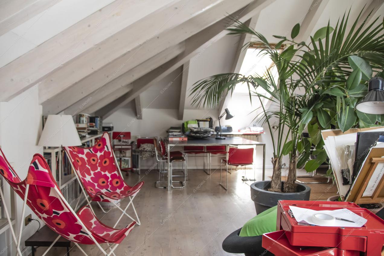 Solaio con pavimento in parquet, travi in legno a vista sul soffitto e scrivanie