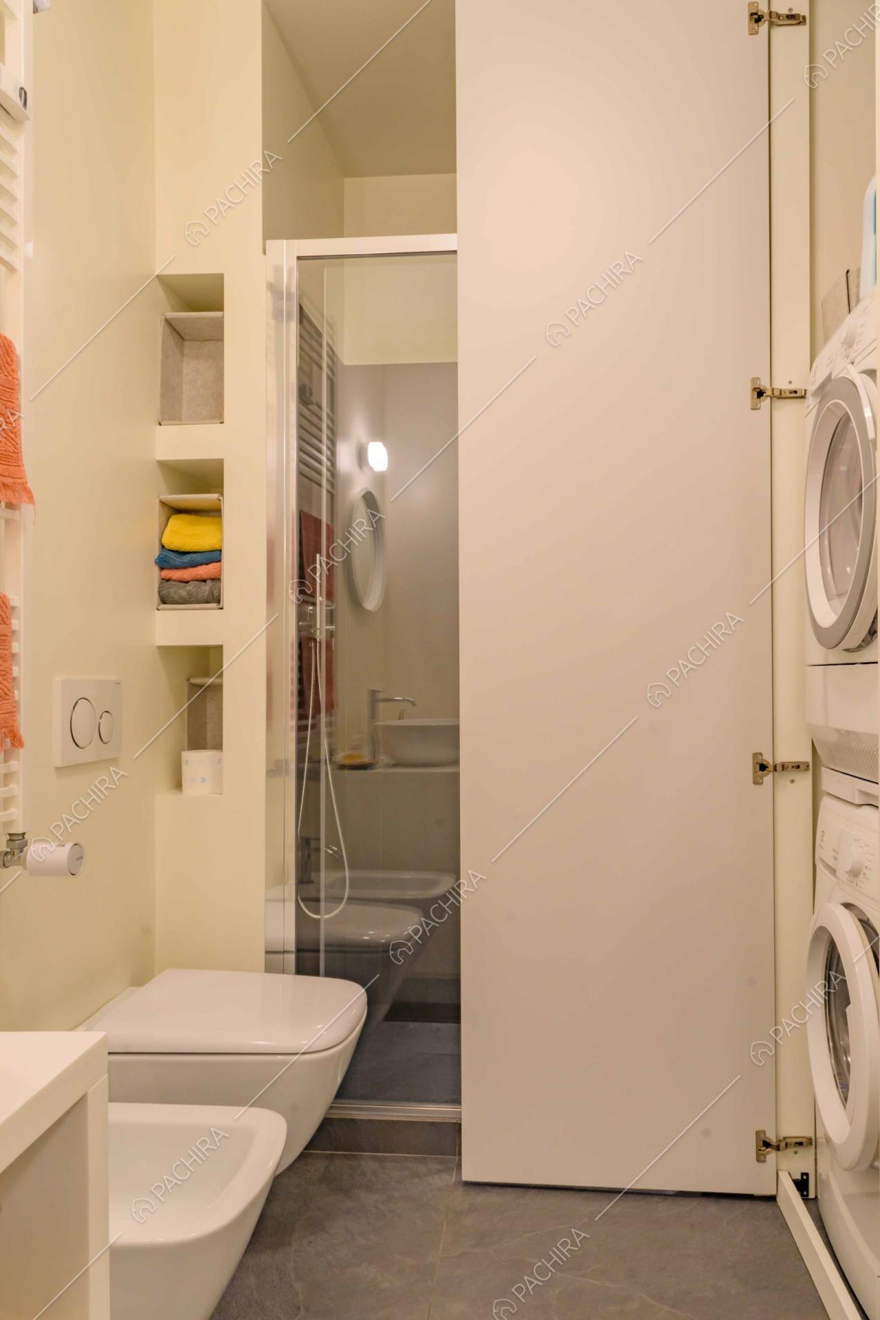 Bagno dal pavimento grigio e dalle pareti bianche con box doccia