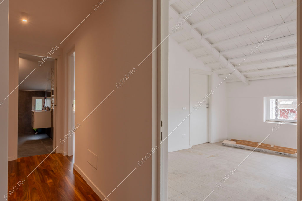 Camera con travi a vista sul soffitto della villa Murray, location in stile contemporaneo a Roma
