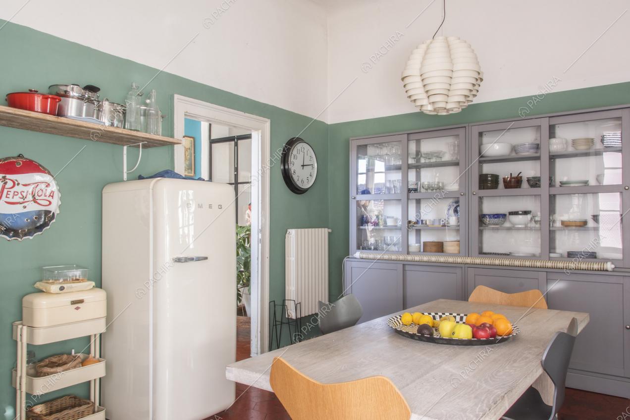 Frigorifero di design bianco, tavolo da pranzo e lampada a sospensione moderna