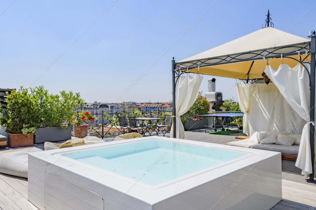 Piscina quadrata e gazebo in ferro con tende bianche ai lati