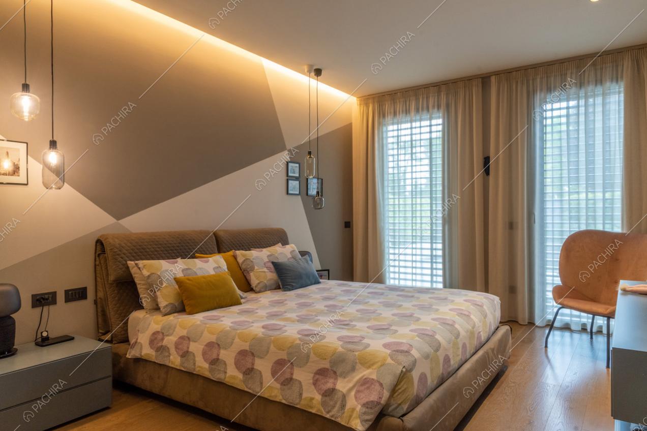 Camera da letto matrimoniale con pavimento in parquet e parete a scacchi irregolari