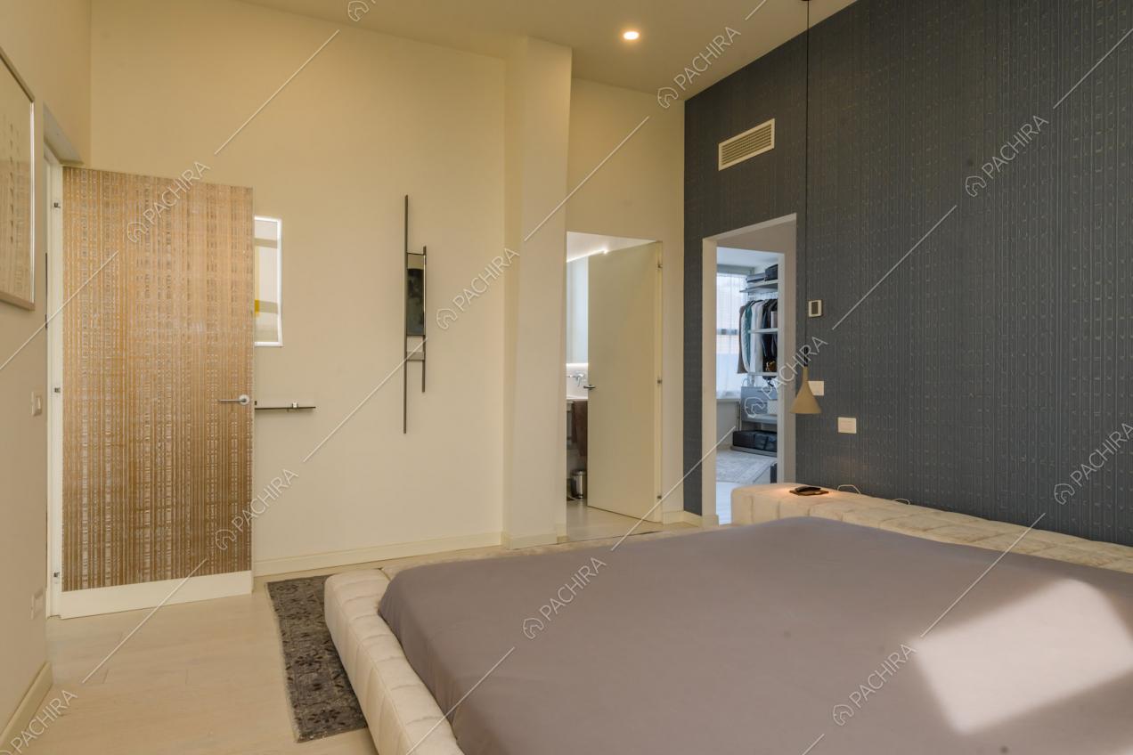 Camera da letto matrimoniale con parete blu, cabina armadio e bagno privato