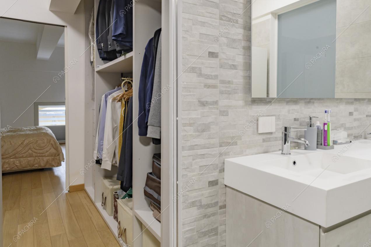 Bagno privato della camera da letto con cabina armadio e pavimento in parquet