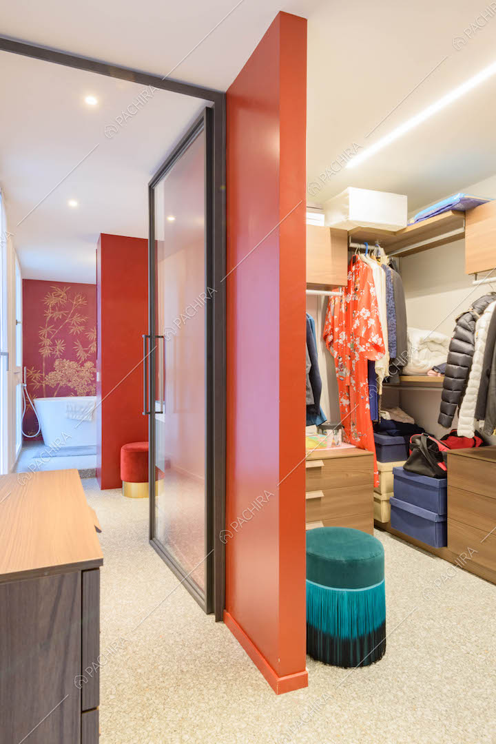 Cabina armadio della camera da letto matrimoniale e scorcio sul bagno dalle pareti rosse