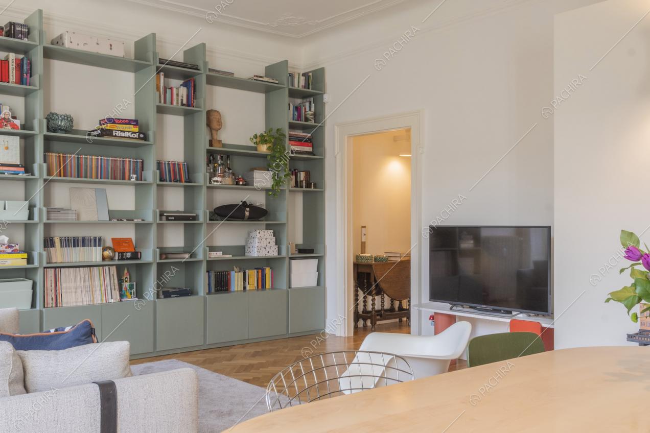 Libreria a parete con libri e soprammobili in salotto