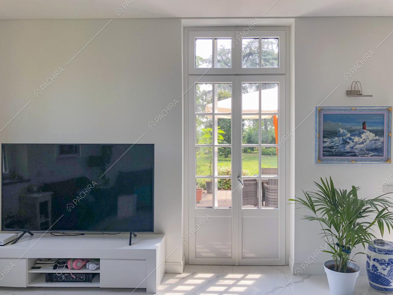 Televisore su mobile bianco e pianta in vaso