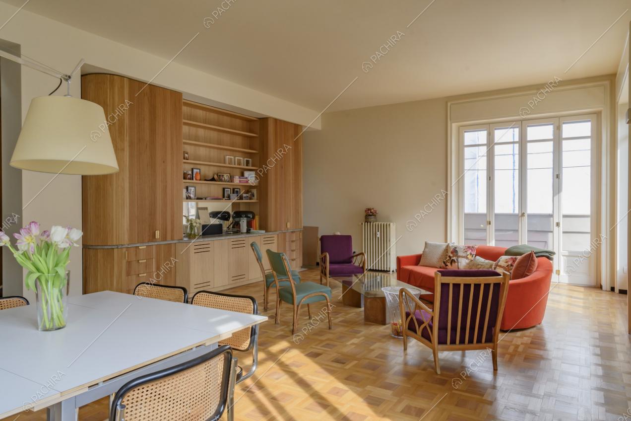 Tavolo da pranzo bianco nel luminoso soggiorno con pavimento in parquet