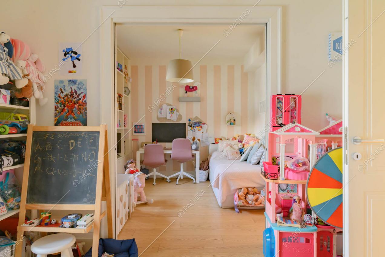 Camera da letto dei bambini con parete a strisce bianche e rosa
