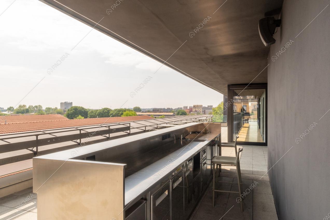 Bancone con sgabelli sulla terrazza con vista sullo skyline di Milano