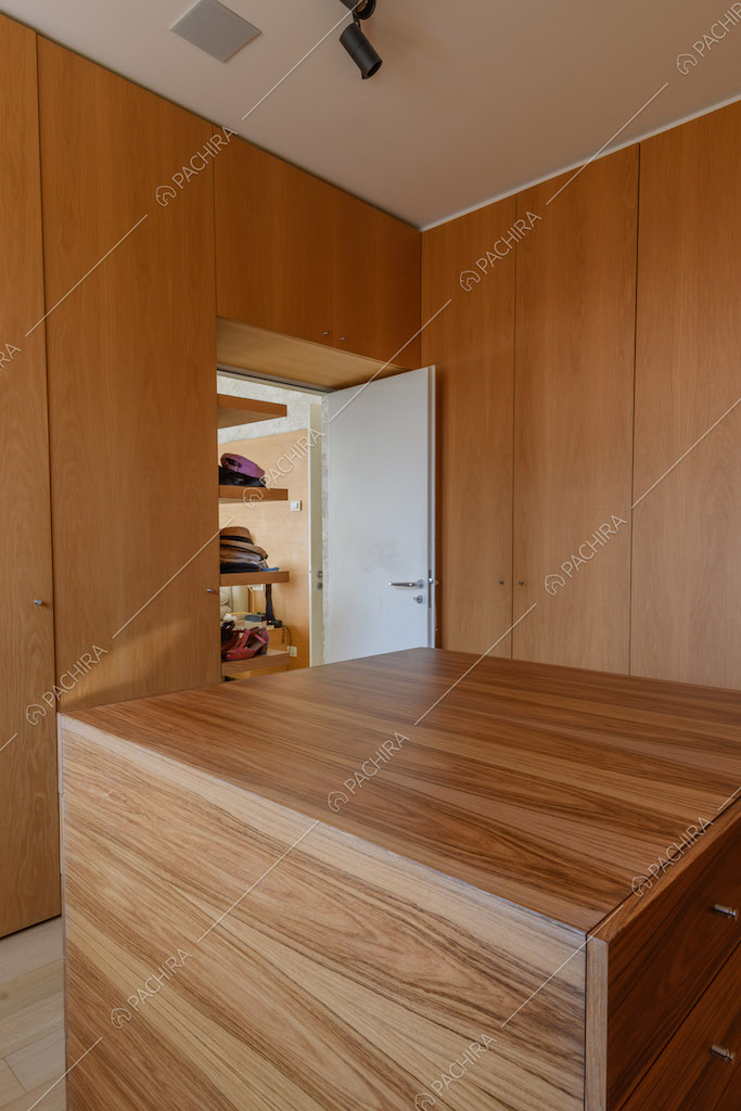 Cabina armadio con pareti in legno, pavimento in parquet e cassettiera