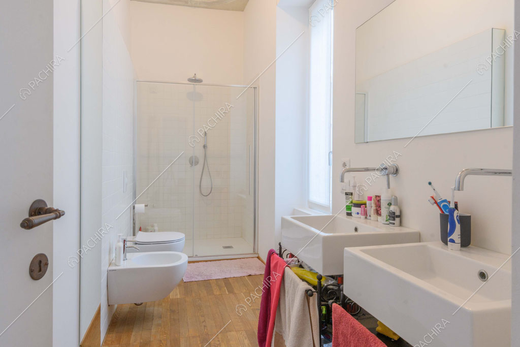 Grande bagno con box-doccia, sanitari sospesi e doppio lavandino