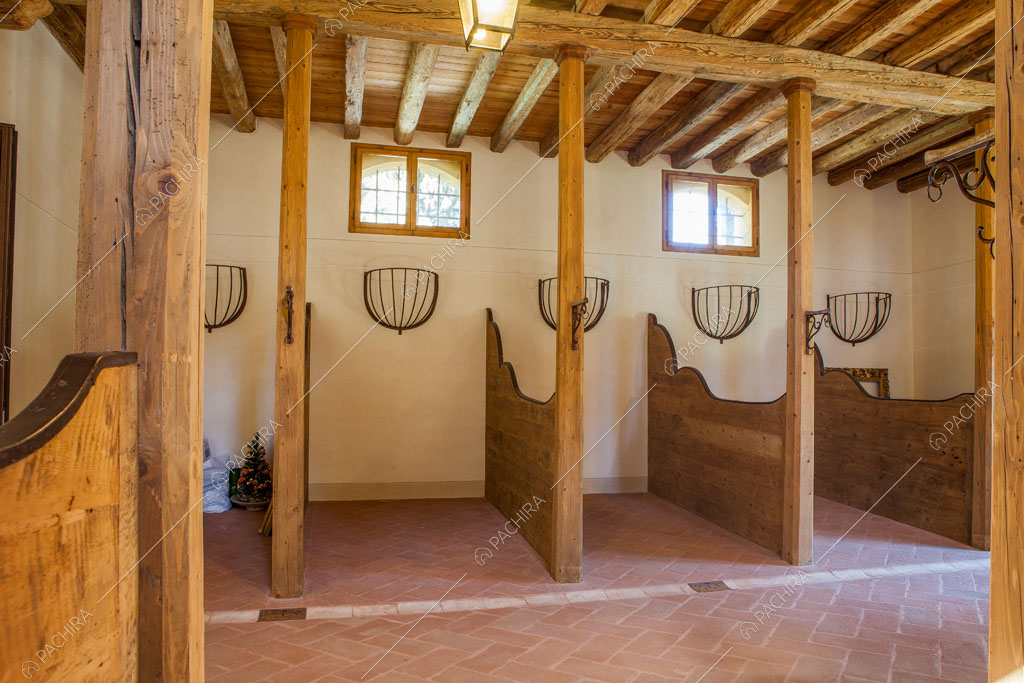 Ex stalla per cavalli con pavimento in cotto e soffitto in travi in legno a vista