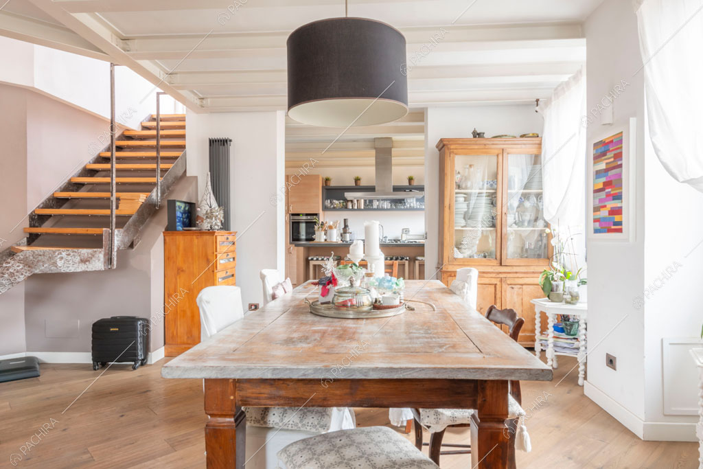Sala con travi a vista sul soffitto dell'appartamento Uru, location in stile moderno a Roma