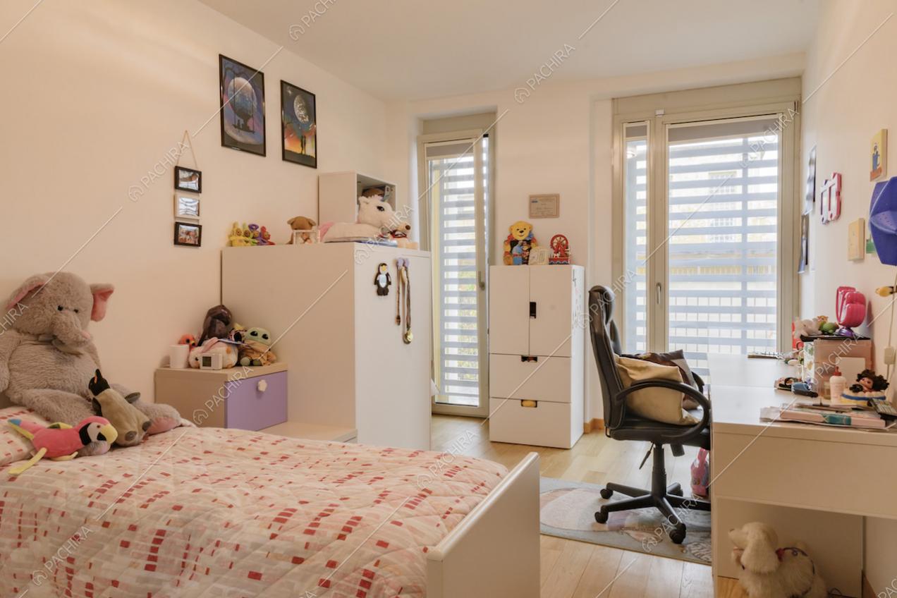 Cameretta da bambini dai toni caldi con scrivania e pavimento in parquet