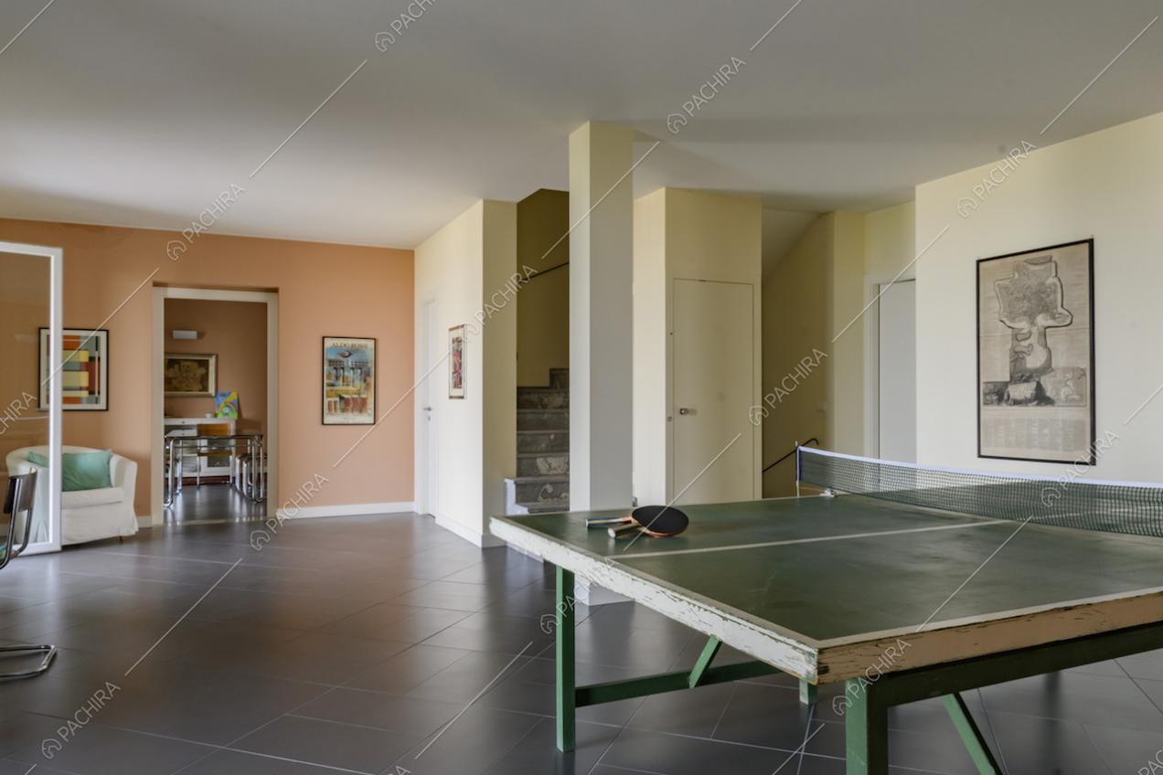 Salotto con tavolo da ping pong e vista sulla sala accanto
