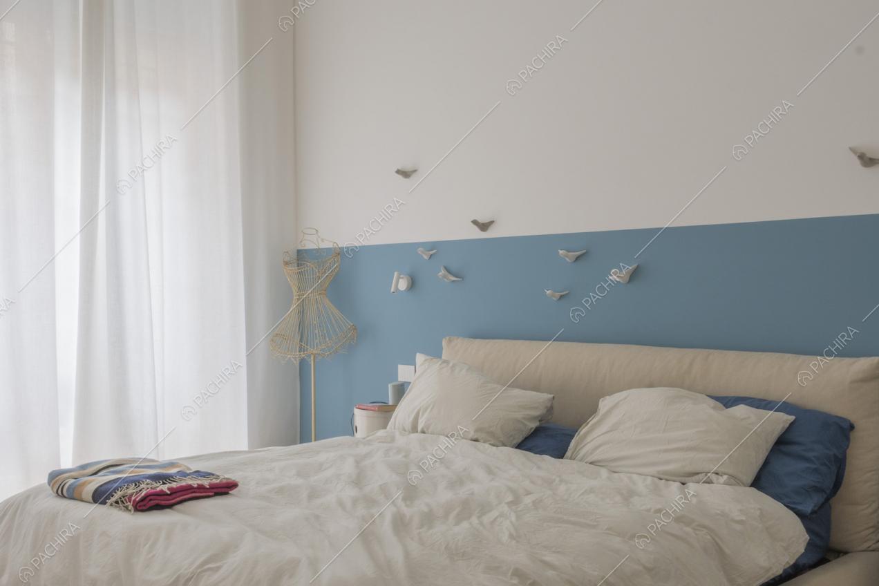 Letto matrimoniale con decorazioni applicate sulla parete