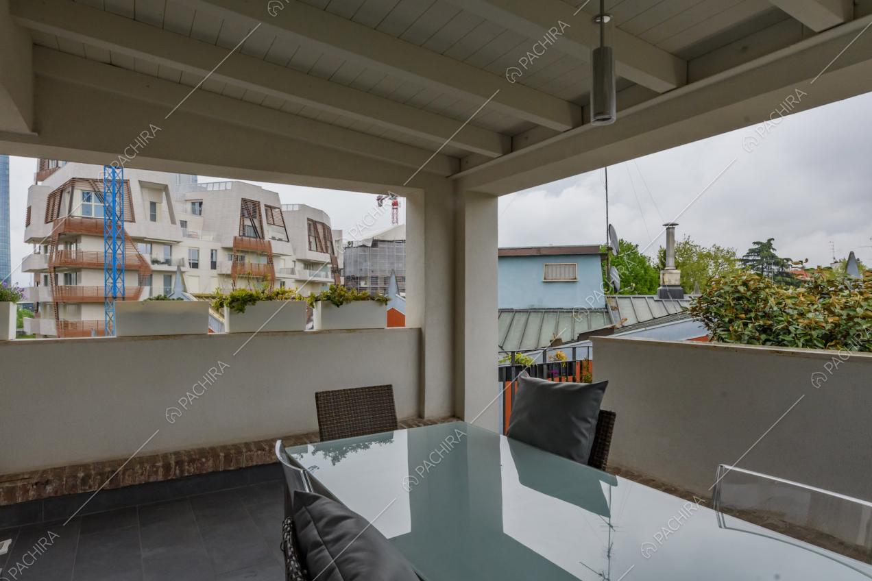 Tavolo da pranzo in vetro sulla veranda con soffitto in travi in legno a vista