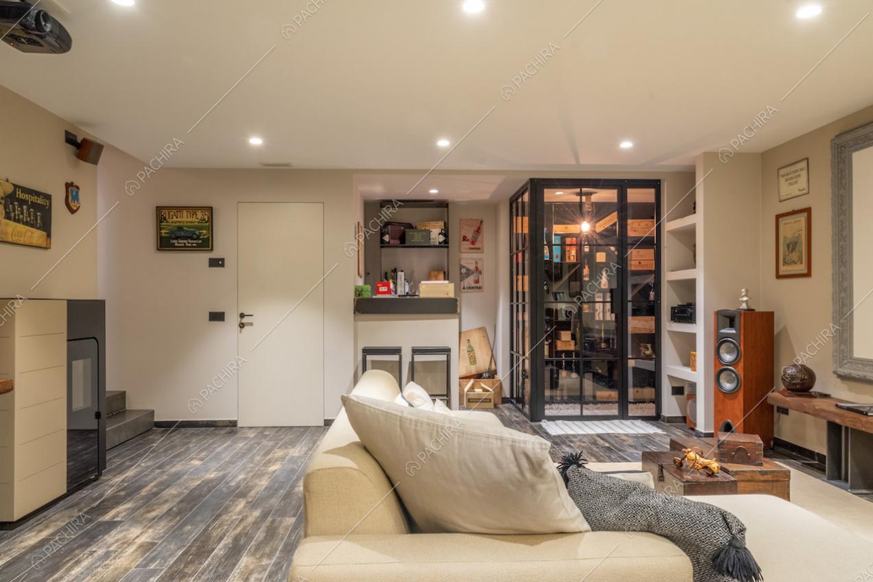 Divano bianco nella sala hobby con pavimento in parquet e cantina