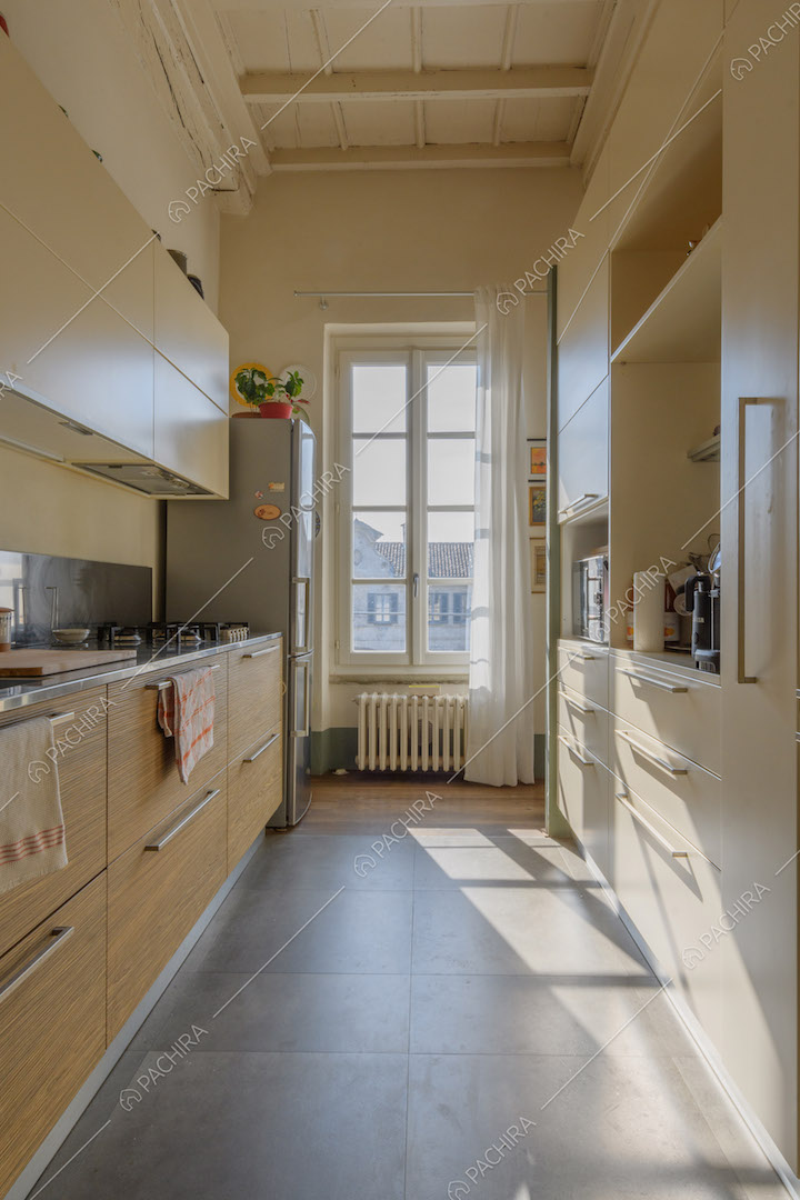 Luminosa cucina a parete con soffitto bianco a cassettoni e fornelli a gas
